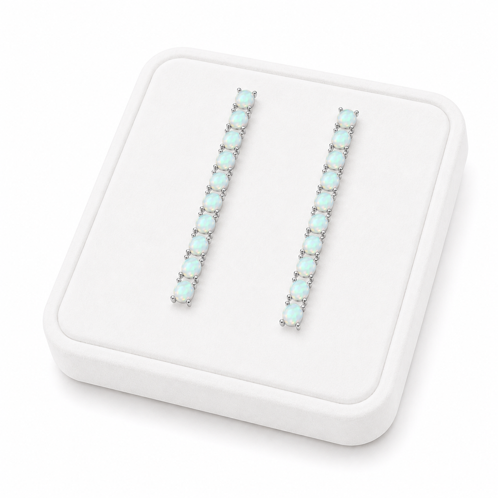 Phimsera natural fire opal dangle earrings displayed on a flat white velvet jewelry tray against a completely white background