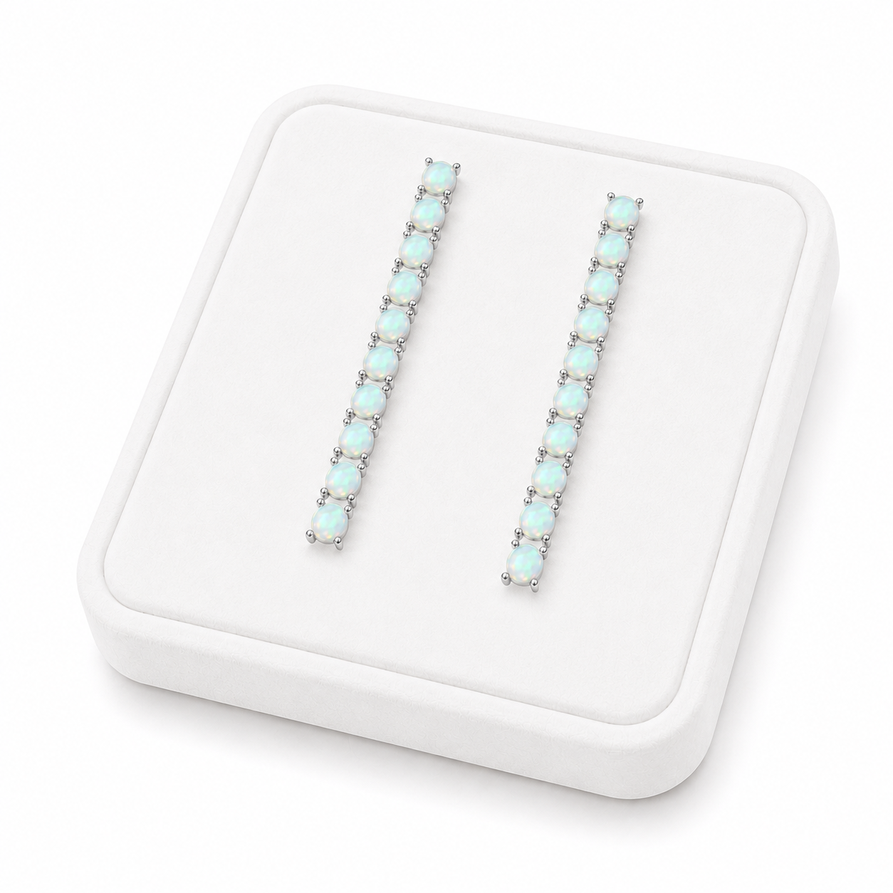 Phimsera natural fire opal dangle earrings displayed on a flat white velvet jewelry tray against a completely white background