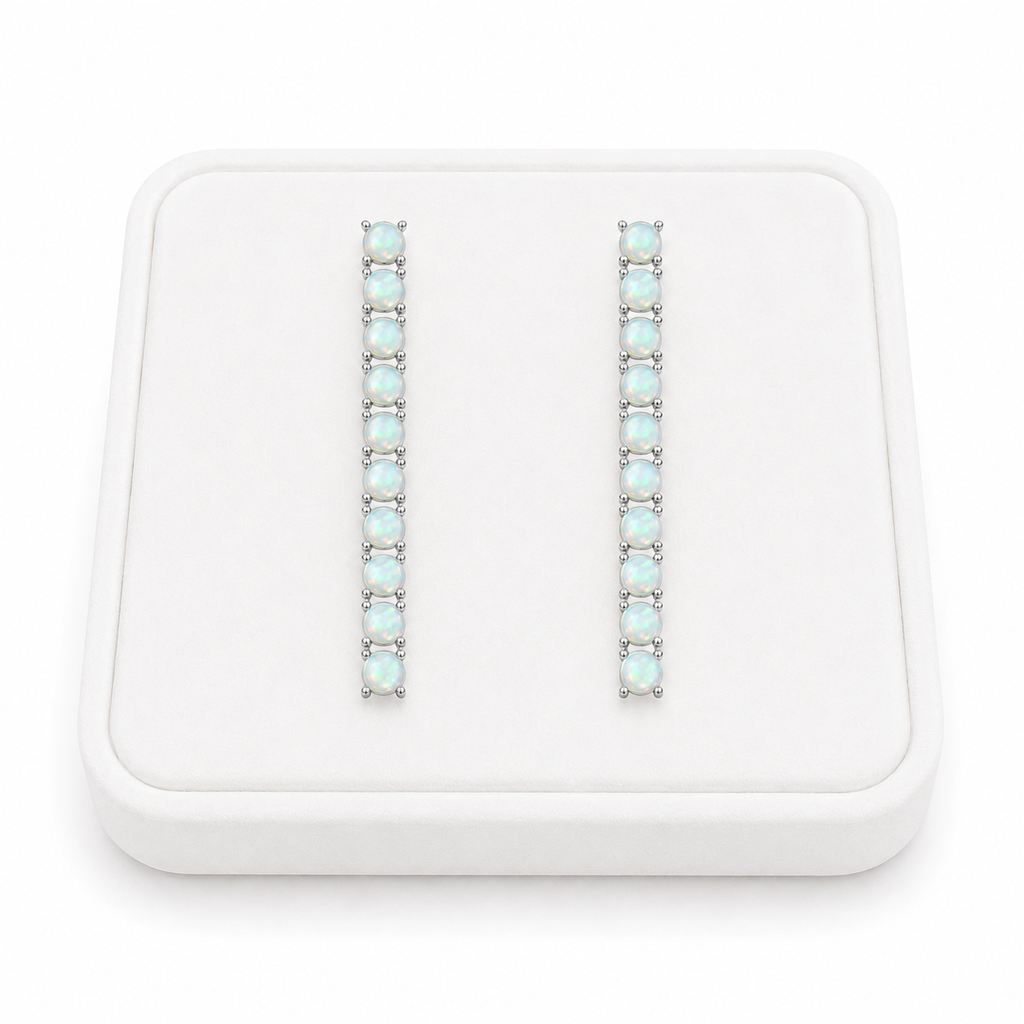 Phimsera natural fire opal dangle earrings displayed on a flat white velvet jewelry tray against a completely white background