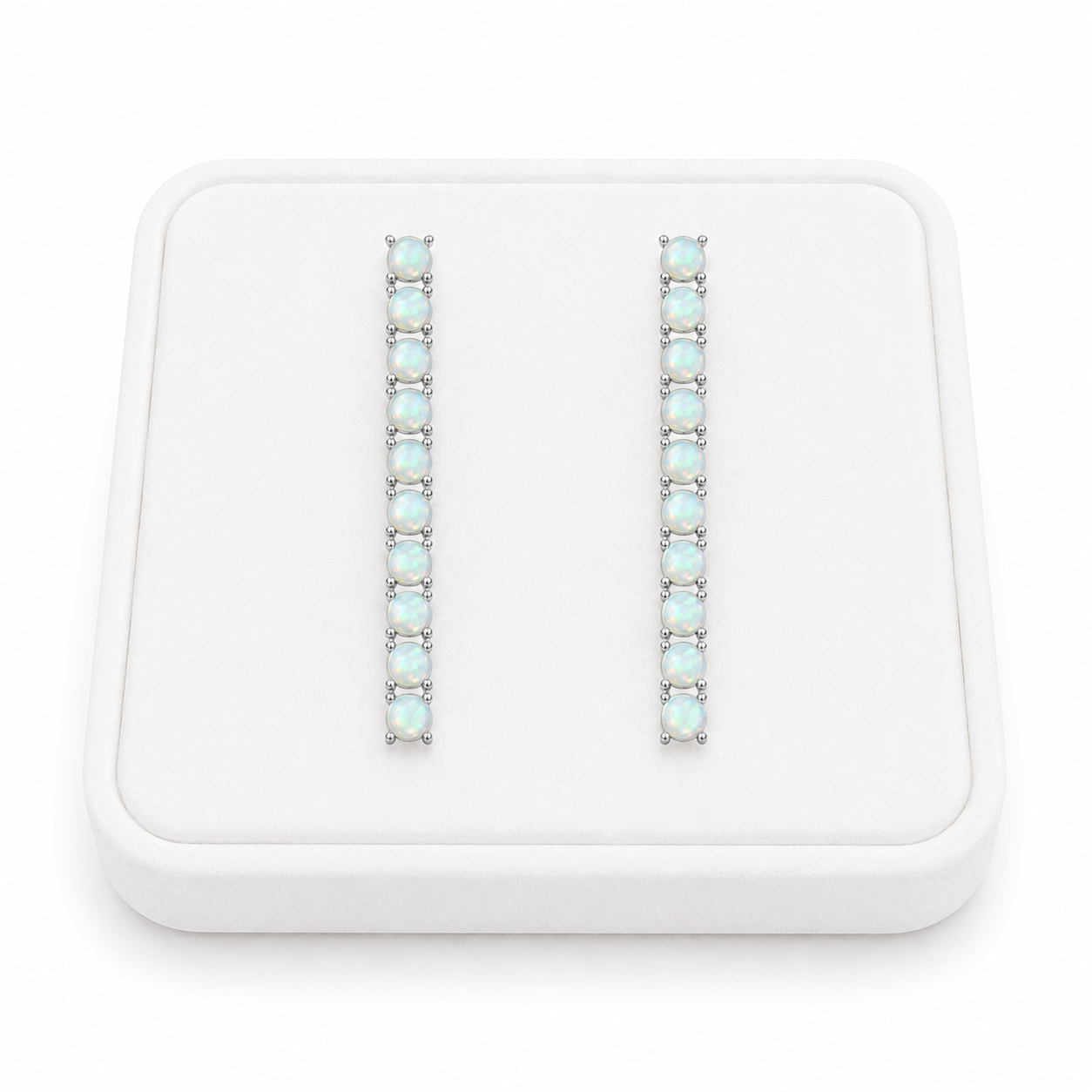 Phimsera natural fire opal dangle earrings displayed on a flat white velvet jewelry tray against a completely white background
