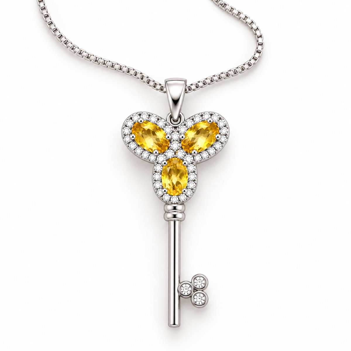 Top-down view of a natural citrine gemstone key-inspired pendant necklace featuring three 3x5mm golden-yellow citrine gemstones in 925 Sterling Silver by Phimsera.