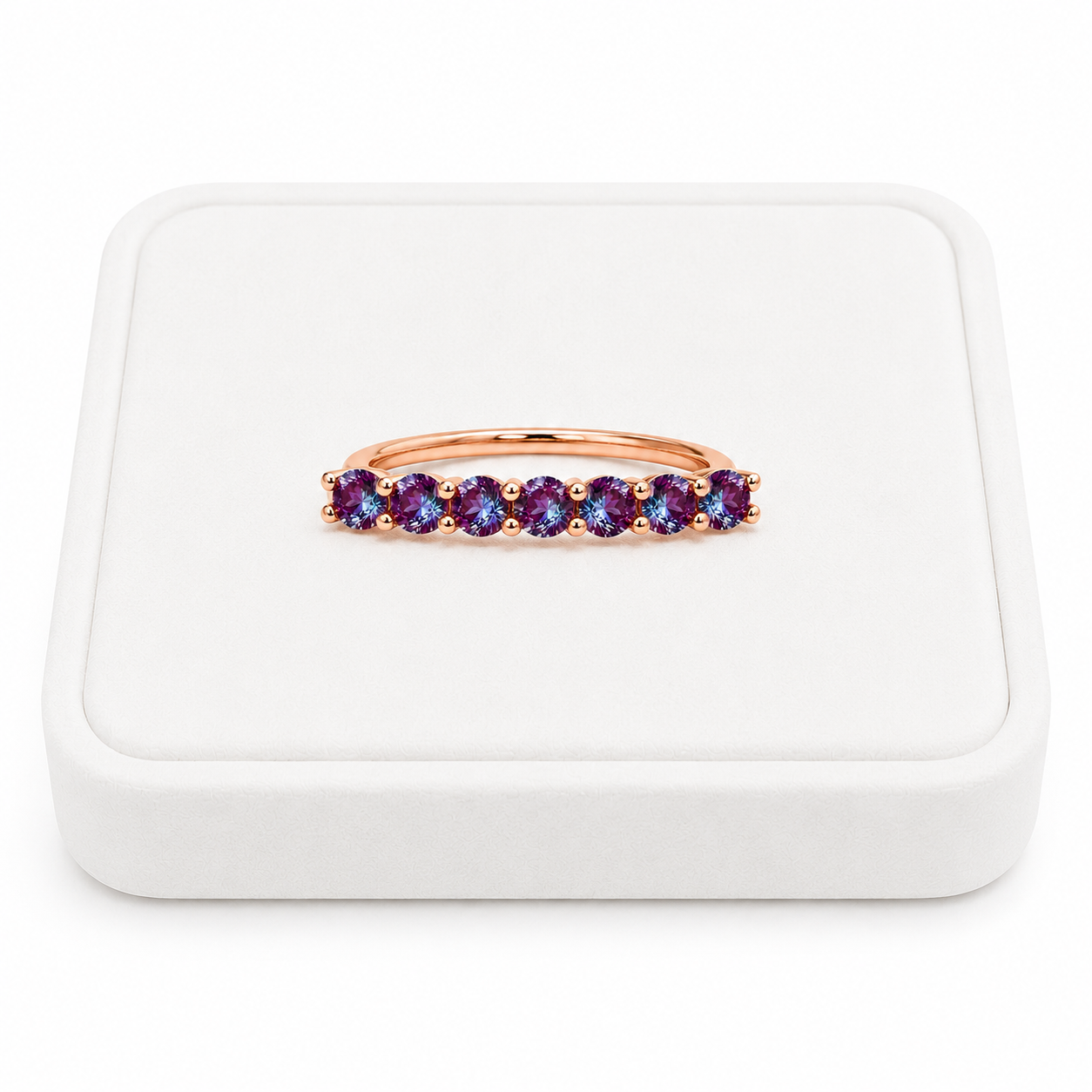 3mm lab alexandrite color changing band ring displayed on a white velvet jewelry tray