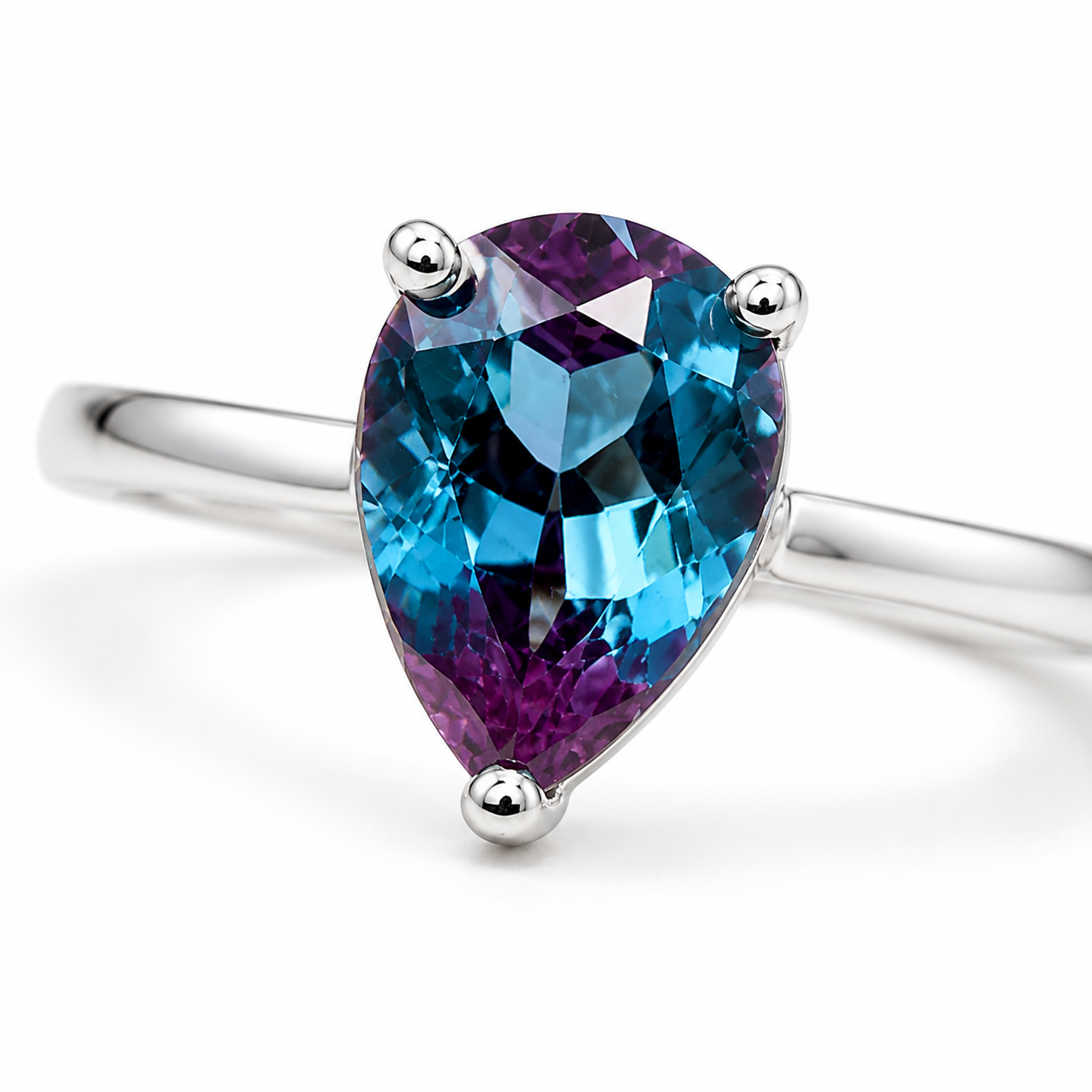Macro view of 5x7mm pear cut lab alexandrite gemstone ring with blue teal violet and purple tones
