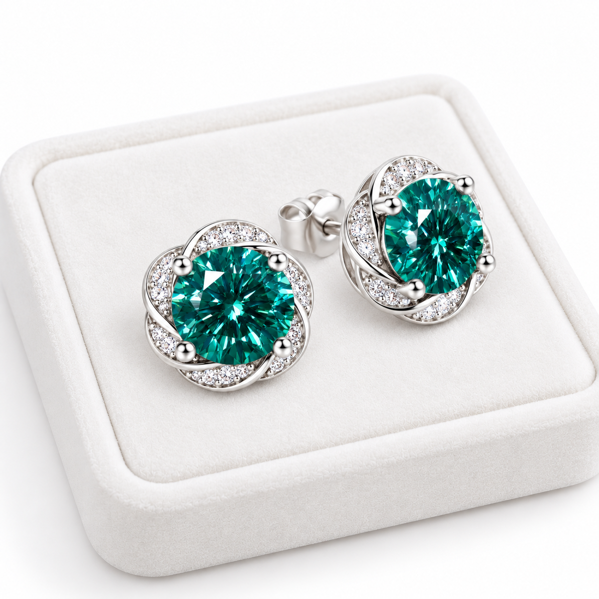 Pair of 6.5mm green moissanite earrings displayed on a white velvet jewelry tray