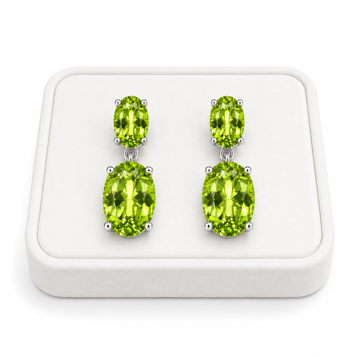 Natural peridot dangle earrings displayed on a white jewelry tray