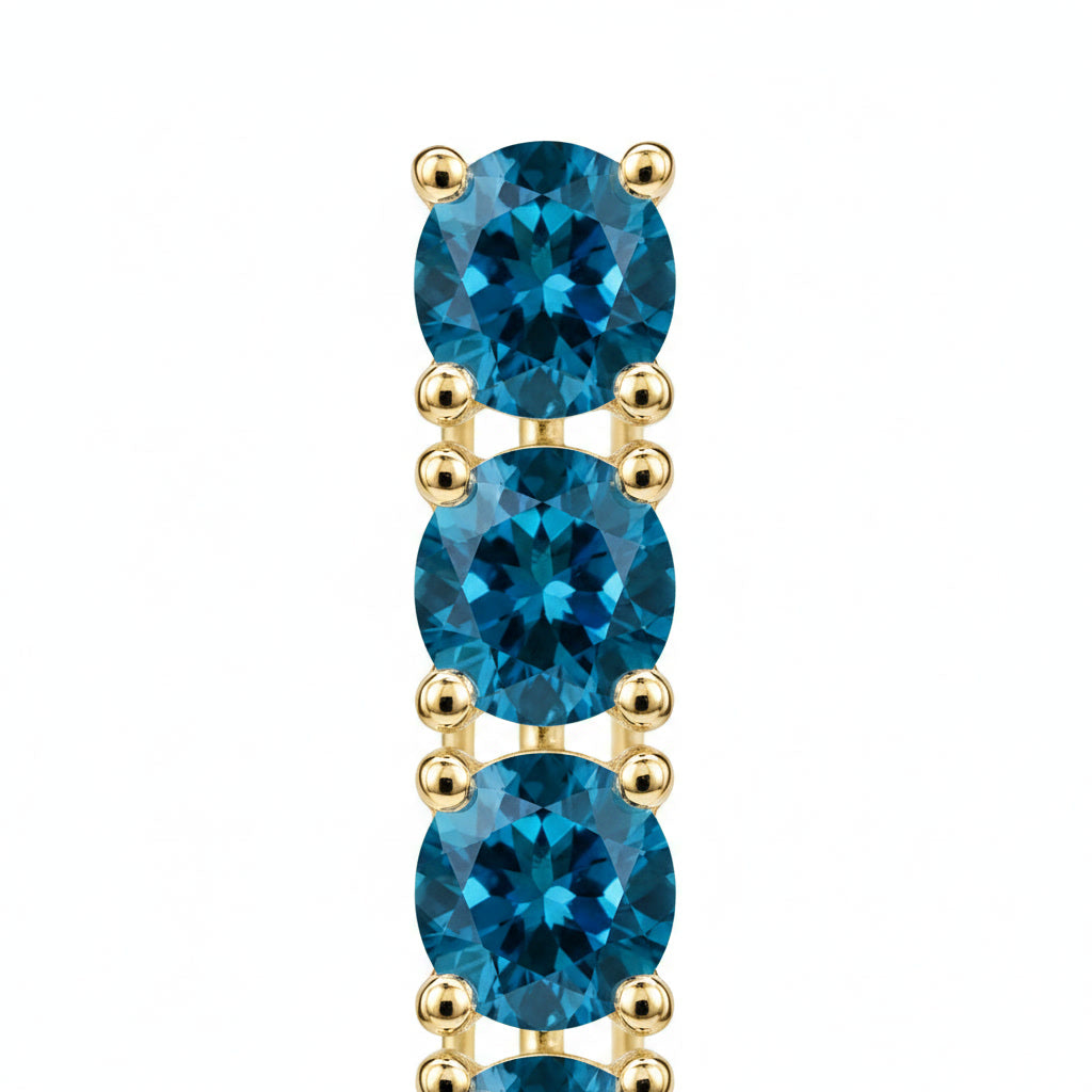 Macro view of 3mm round deep blue London Blue Topaz gemstones in Phimsera sterling silver dangle earrings