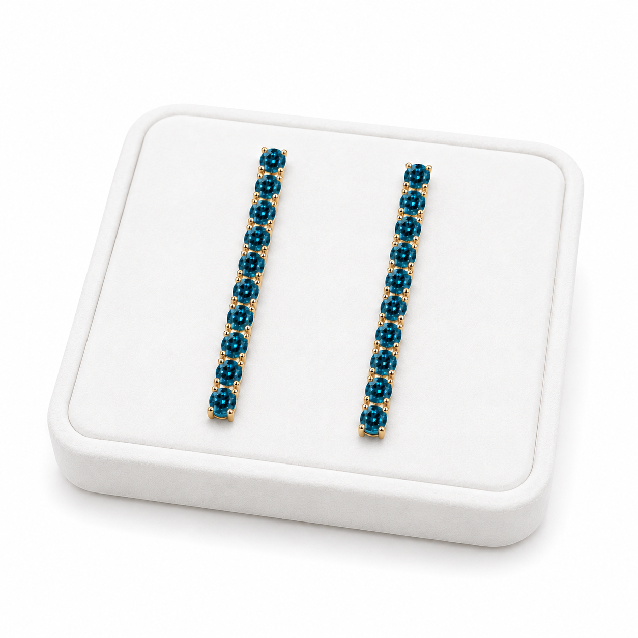 Phimsera London Blue Topaz dangle earrings displayed on a white velvet jewelry tray against a bright white background
