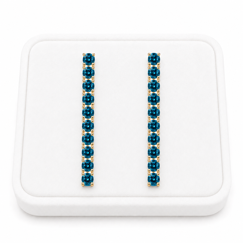 Phimsera London Blue Topaz dangle earrings displayed on a white velvet jewelry tray against a bright white background