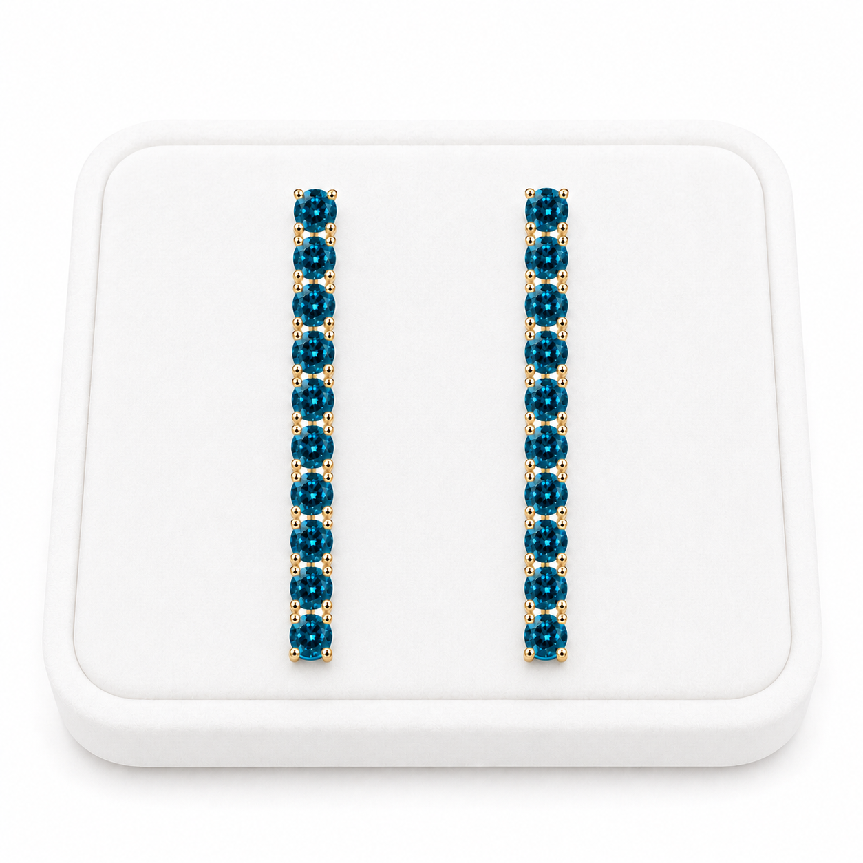 Phimsera London Blue Topaz dangle earrings displayed on a white velvet jewelry tray against a bright white background