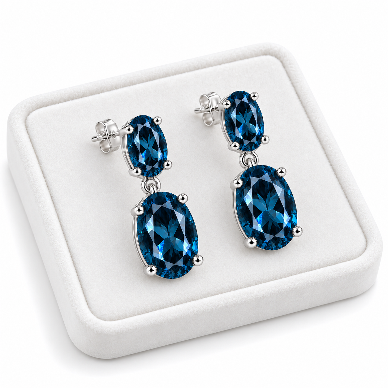 London Blue Topaz dangle earrings displayed on a white velvet jewelry tray