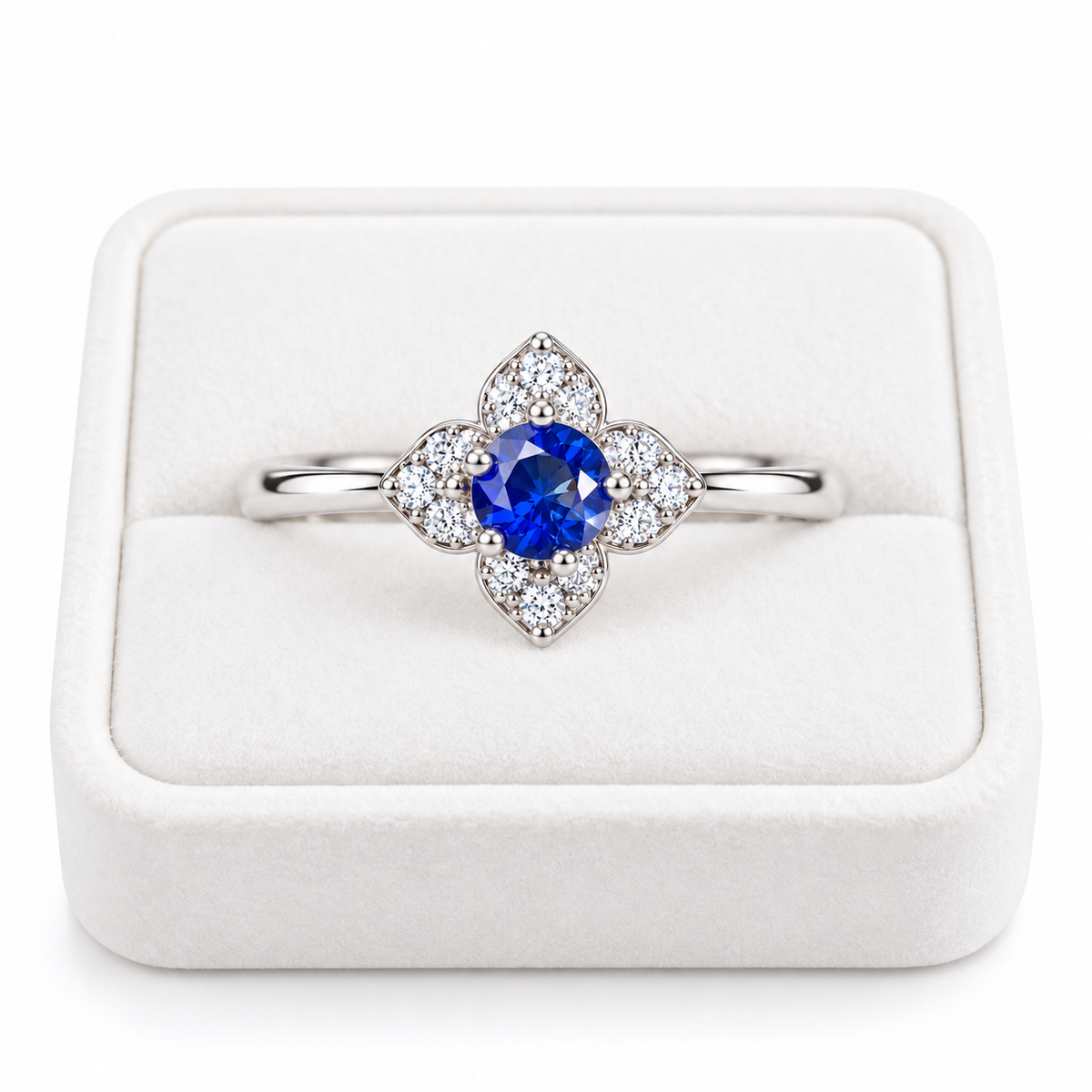 Natural 3.5mm round blue sapphire floral ring displayed on a white velvet jewelry tray