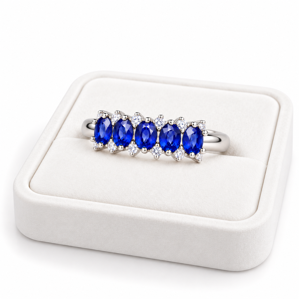 Natural blue sapphire band ring with 3×4mm oval gemstones displayed on a white velvet jewelry tray