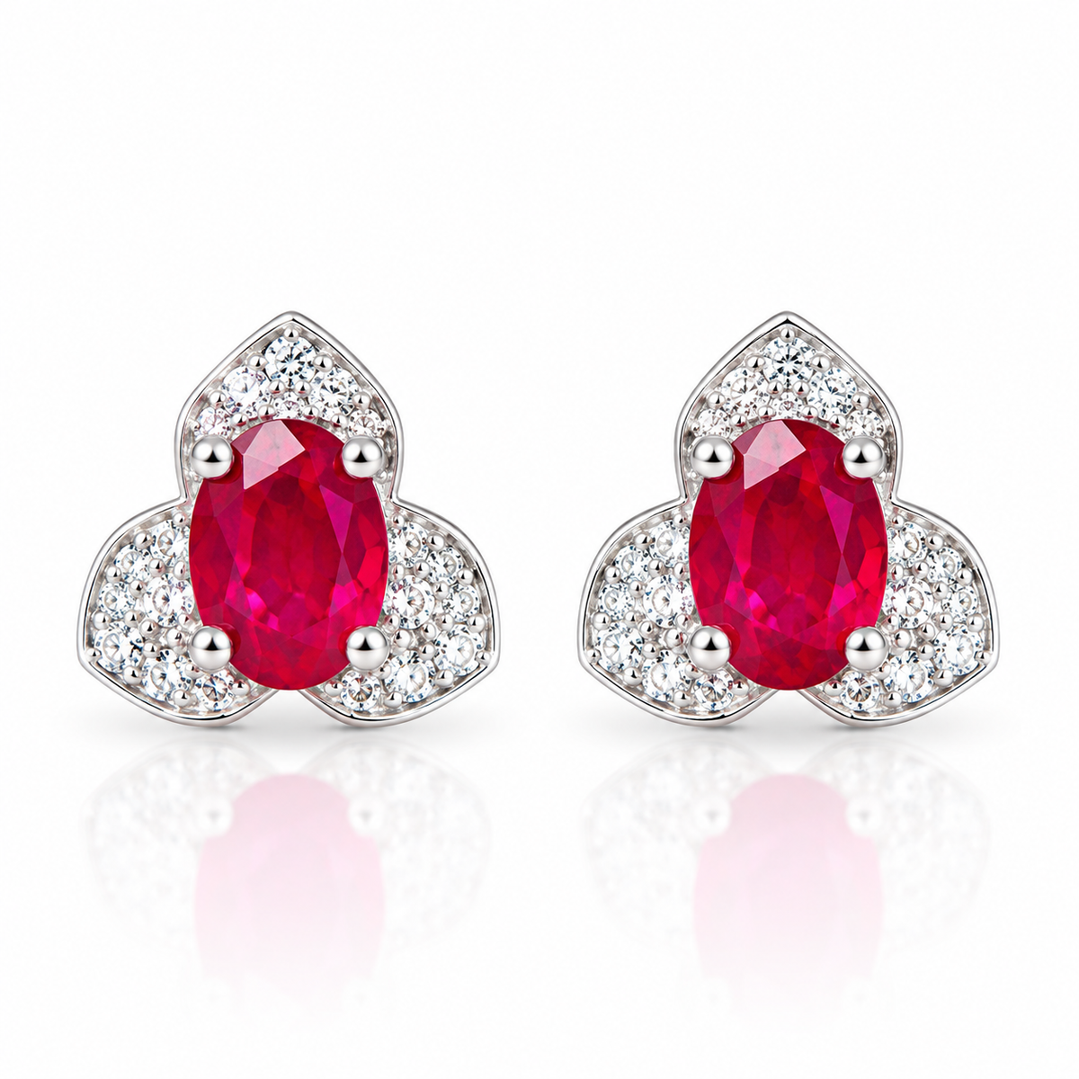 Natural 4×6mm oval ruby stud earrings with vivid red gemstones and cubic zirconia halo in 925 sterling silver by Phimsera