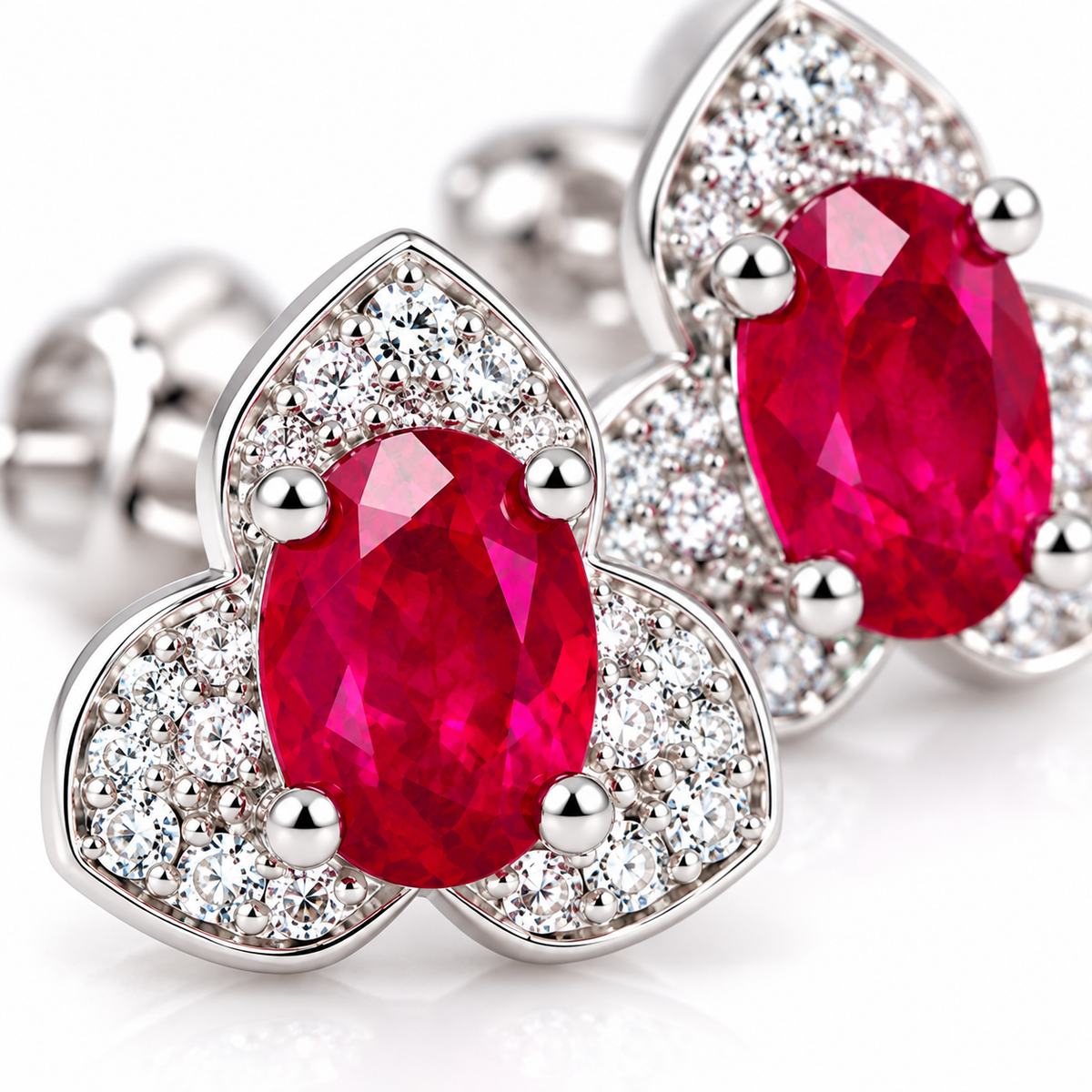 Macro close-up of vivid red 4×6mm oval ruby gemstones and surrounding cubic zirconia accents on Phimsera stud earrings