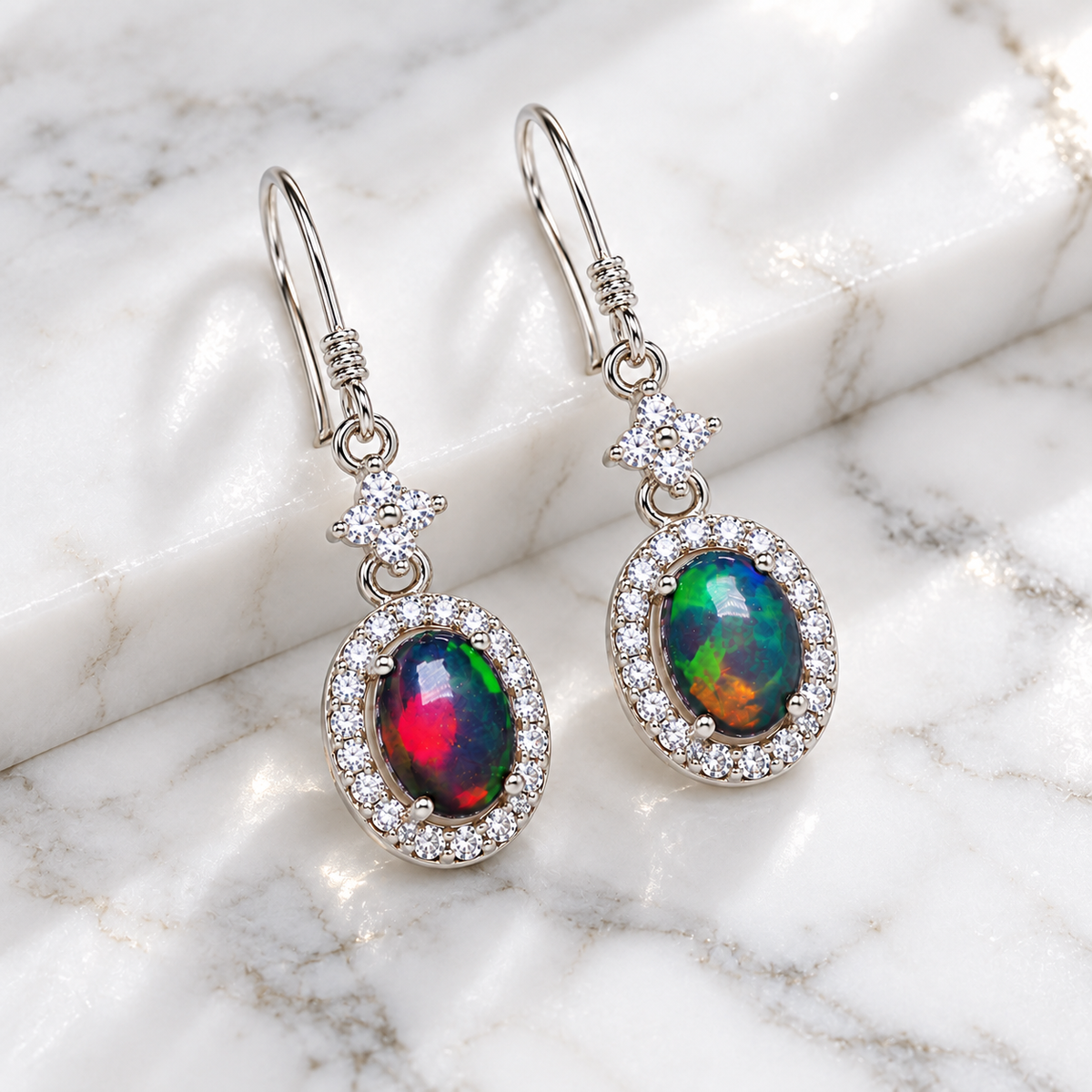 Natural Australian 5x7mm colorful fire opal earrings displayed on bright white marble