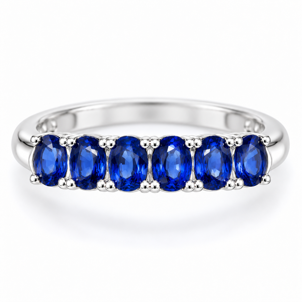 Top-down view of a natural blue sapphire band ring with 3×4mm gemstones arranged across the ring by Phimsera