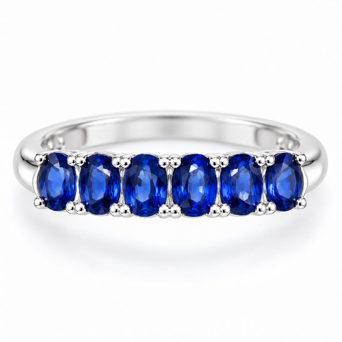 Top-down view of a natural blue sapphire band ring with 3×4mm gemstones arranged across the ring by Phimsera
