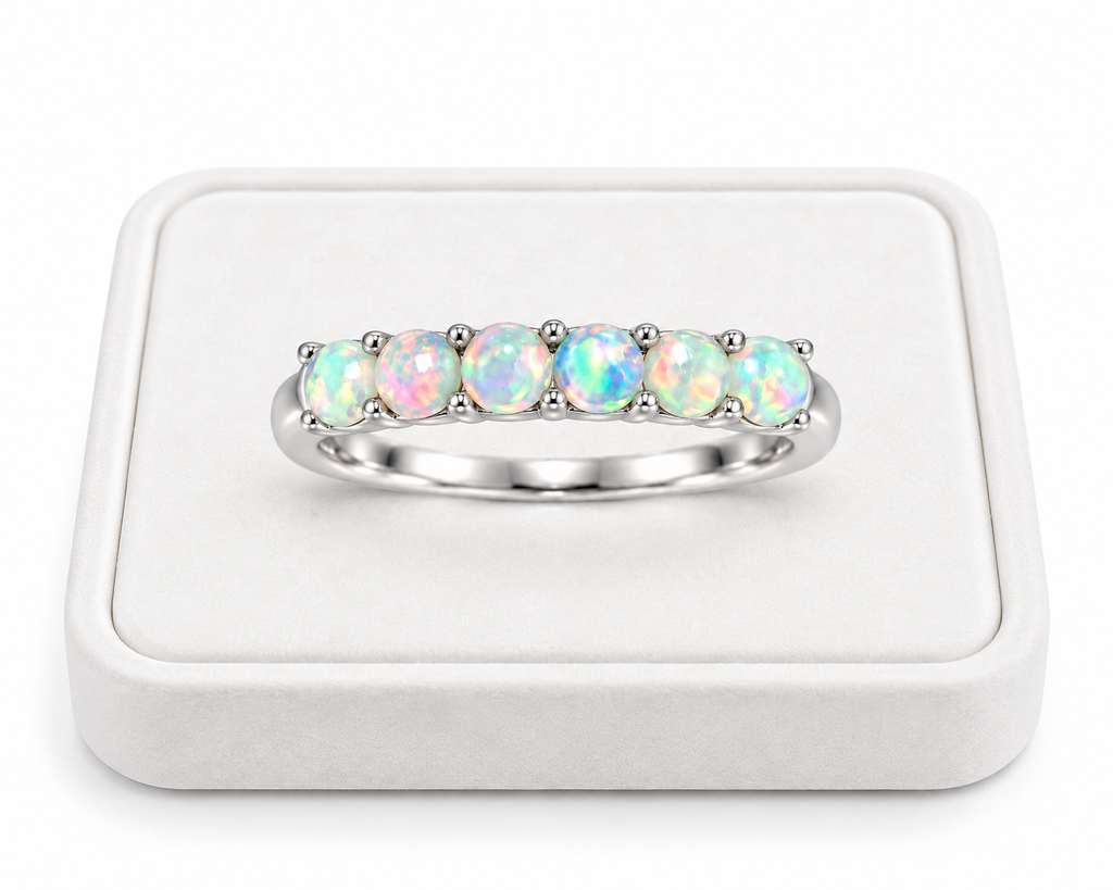 Natural fire opal band ring displayed on a white velvet jewelry tray