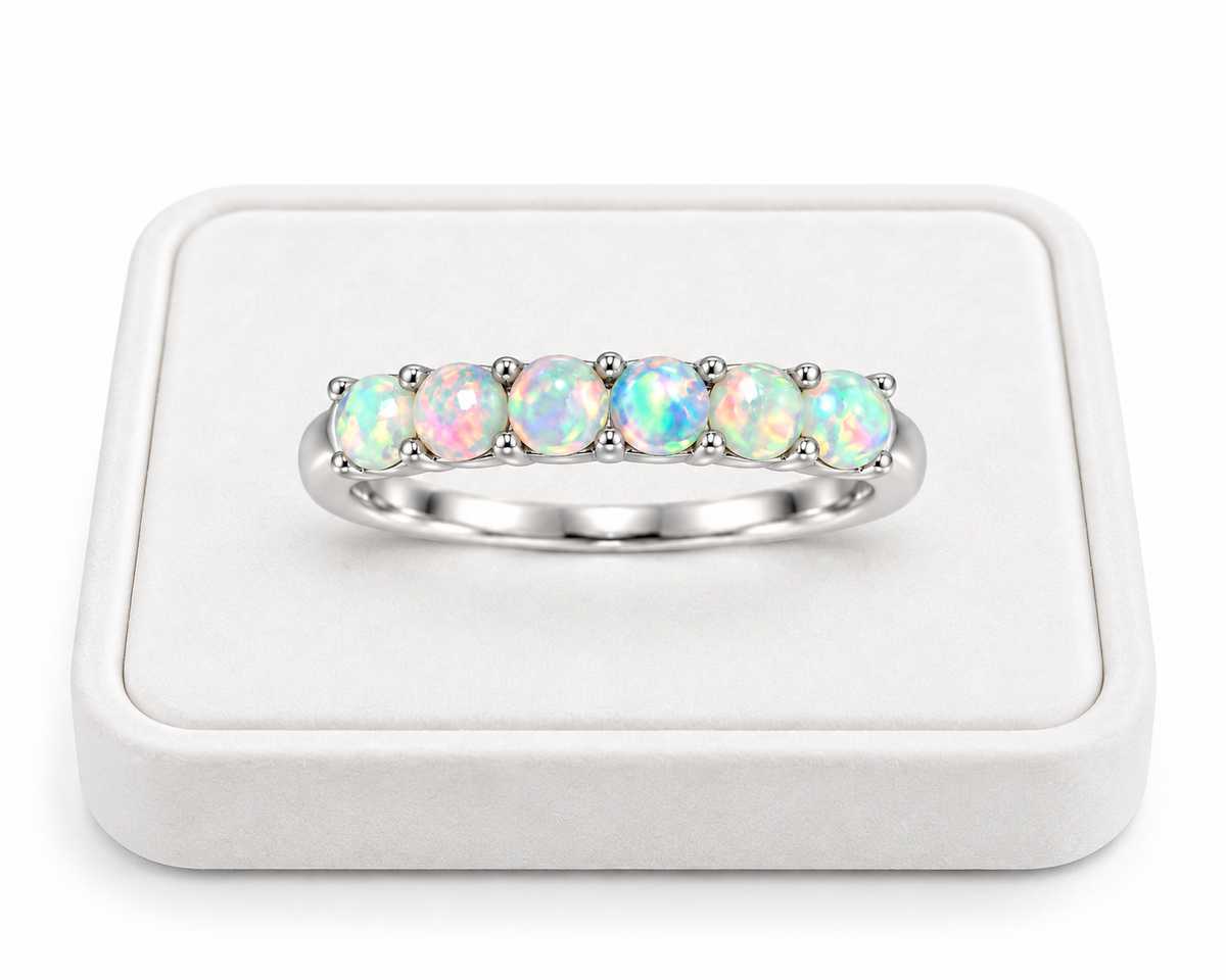 Natural fire opal band ring displayed on a white velvet jewelry tray