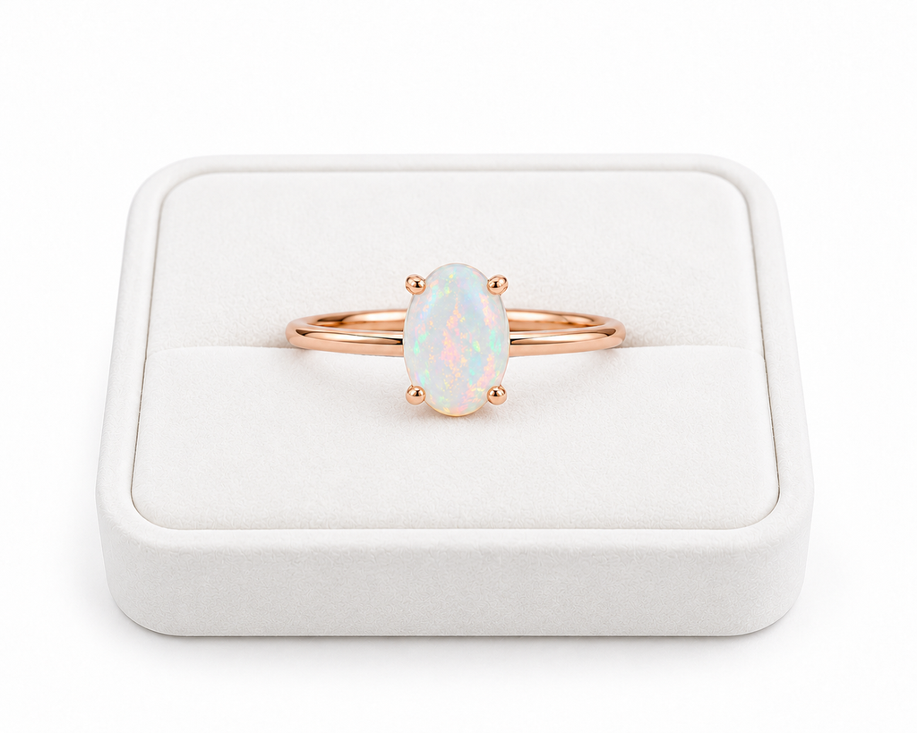 5x7mm natural opal solitaire ring displayed on a white velvet jewelry tray