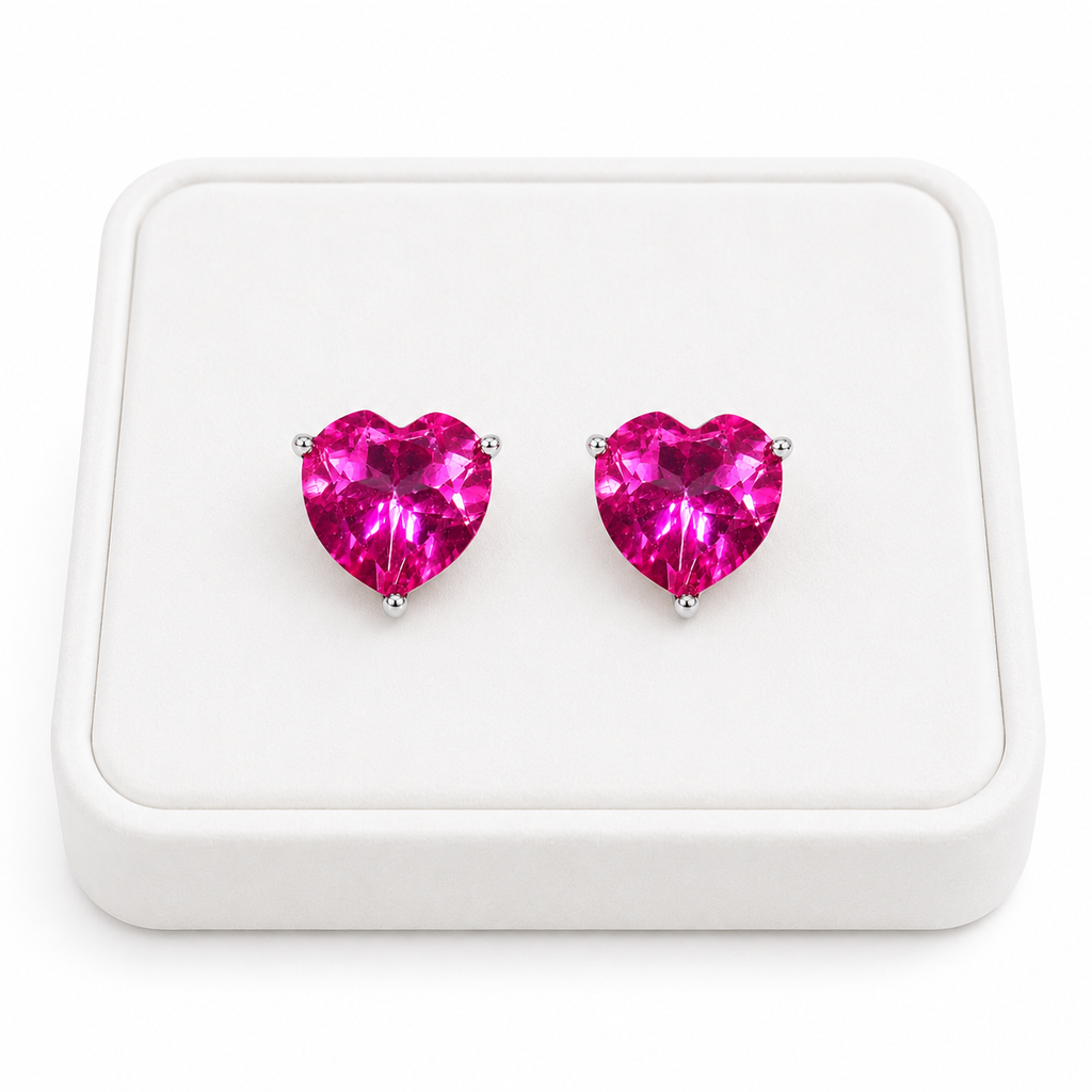 Natural pink topaz heart earrings displayed on white velvet jewelry tray