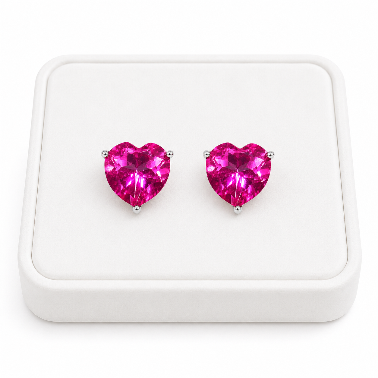 Natural pink topaz heart earrings displayed on white velvet jewelry tray