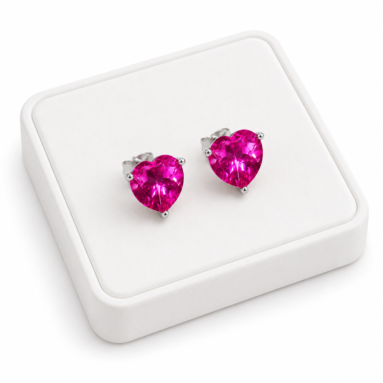 Natural pink topaz heart earrings displayed on white velvet jewelry tray