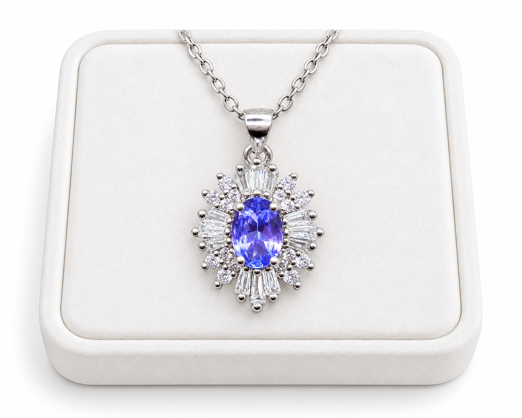 Purple tanzanite pendant necklace arranged on a white velvet jewelry tray against a clean white background.