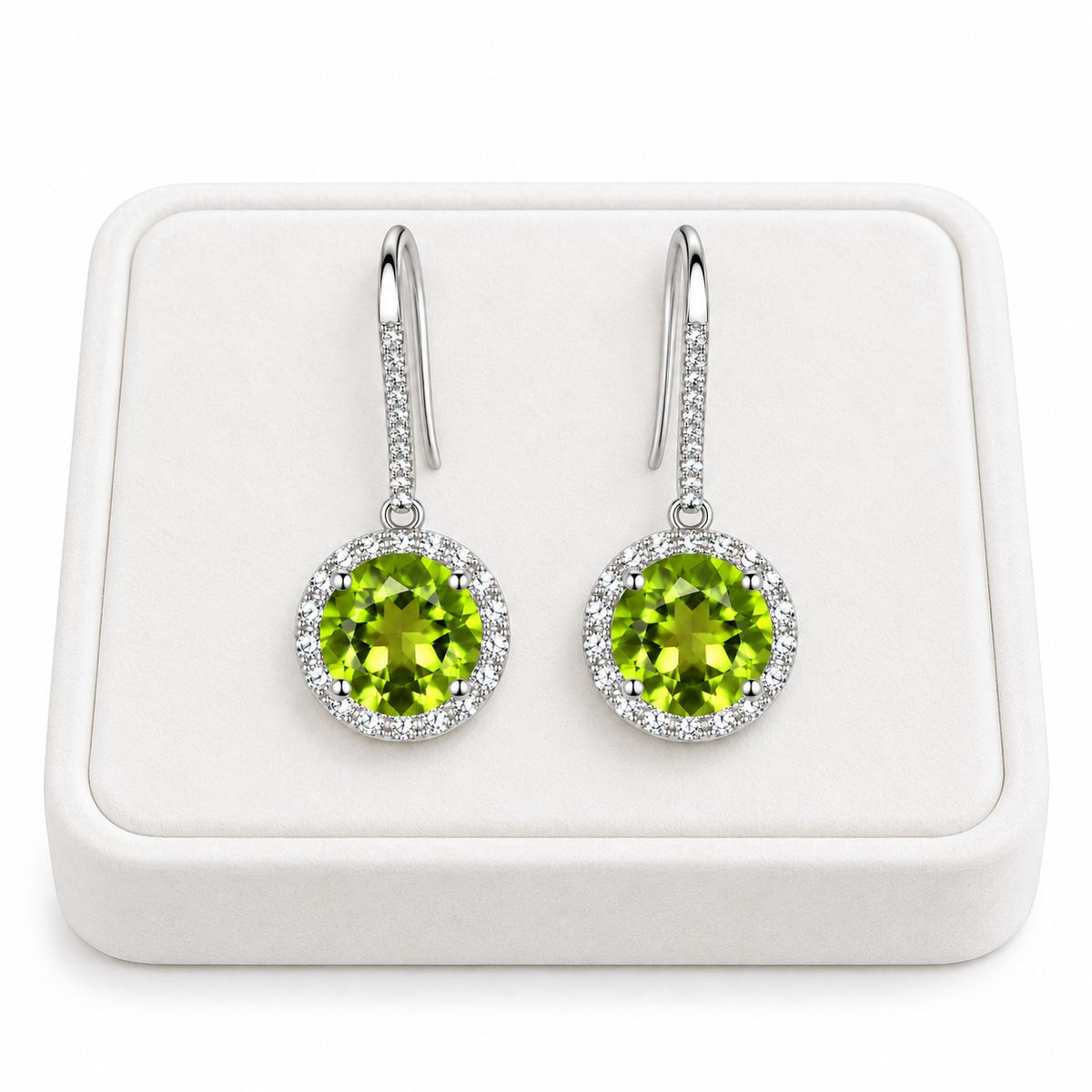 Natural 8mm round peridot drop earrings displayed on a white velvet jewelry tray