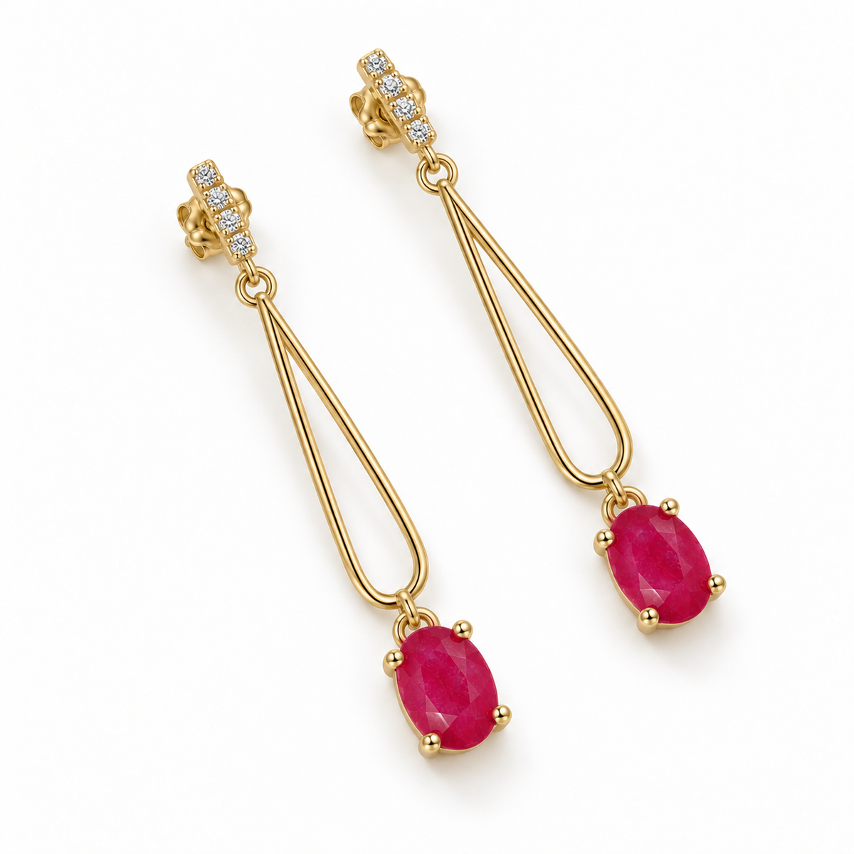 Top-down view of matching Phimsera ruby drop earrings showing the oval 4 × 6 mm ruby gemstones, upper decorative studs, and long loop construction.