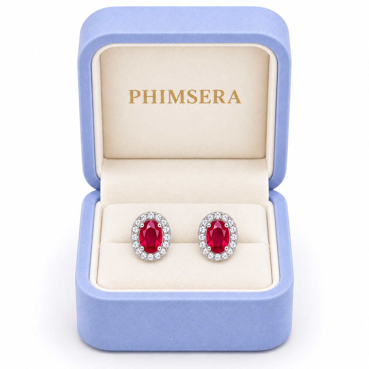 Phimsera natural ruby oval halo stud earrings displayed inside a branded periwinkle and cream jewelry gift box.