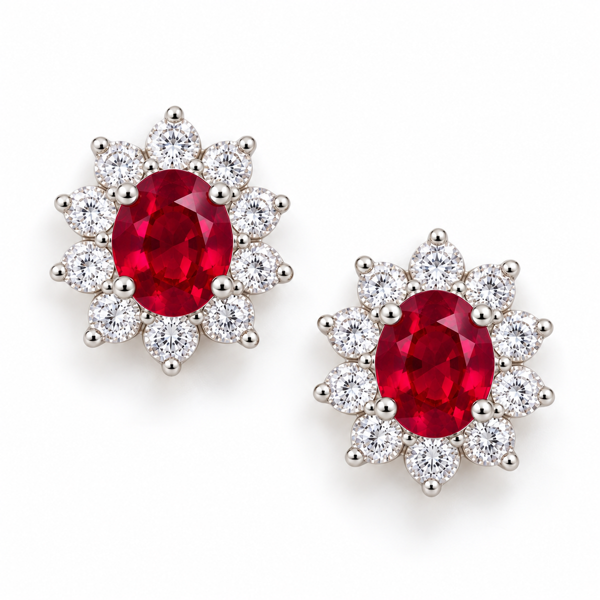 Top-down view of Phimsera ruby stud earrings with vivid red 4 × 5 mm oval center gemstones and surrounding clear accent stones.