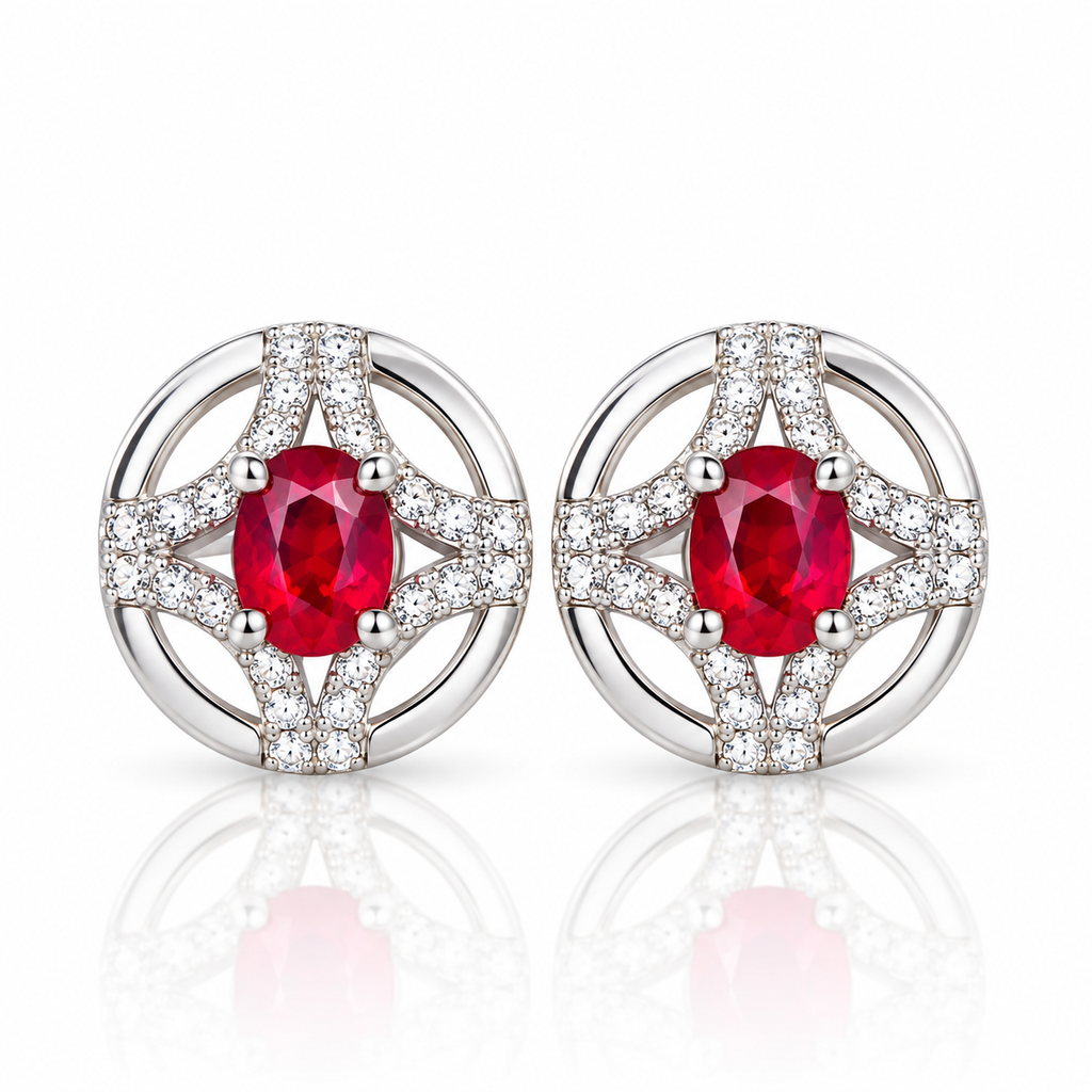Natural ruby stud earrings featuring matching 3 × 4mm oval red ruby gemstones in circular openwork settings with clear accent stones on a white background.