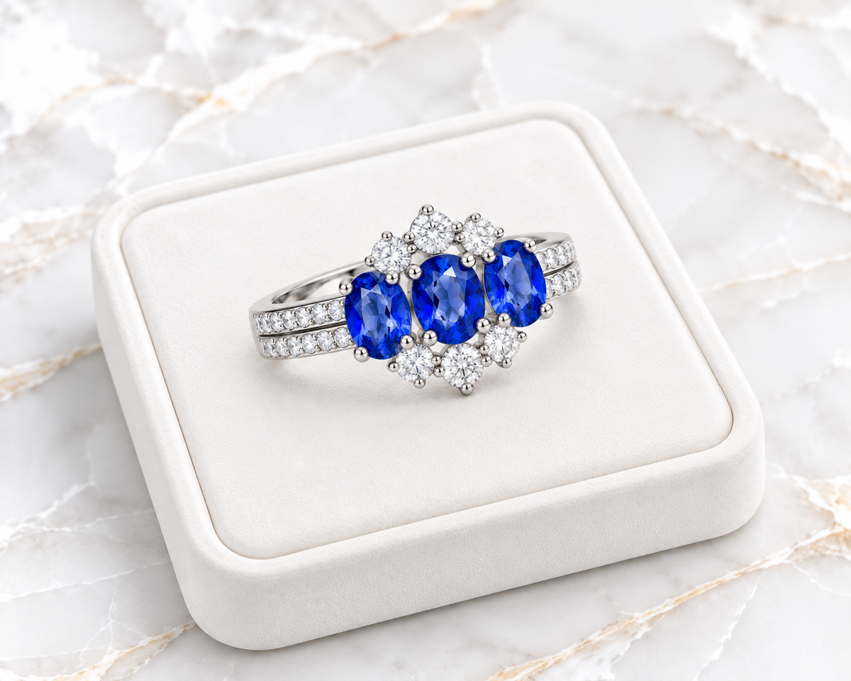 Angled 4x5mm blue sapphire gemstone ring displayed on a white velvet tray over marble