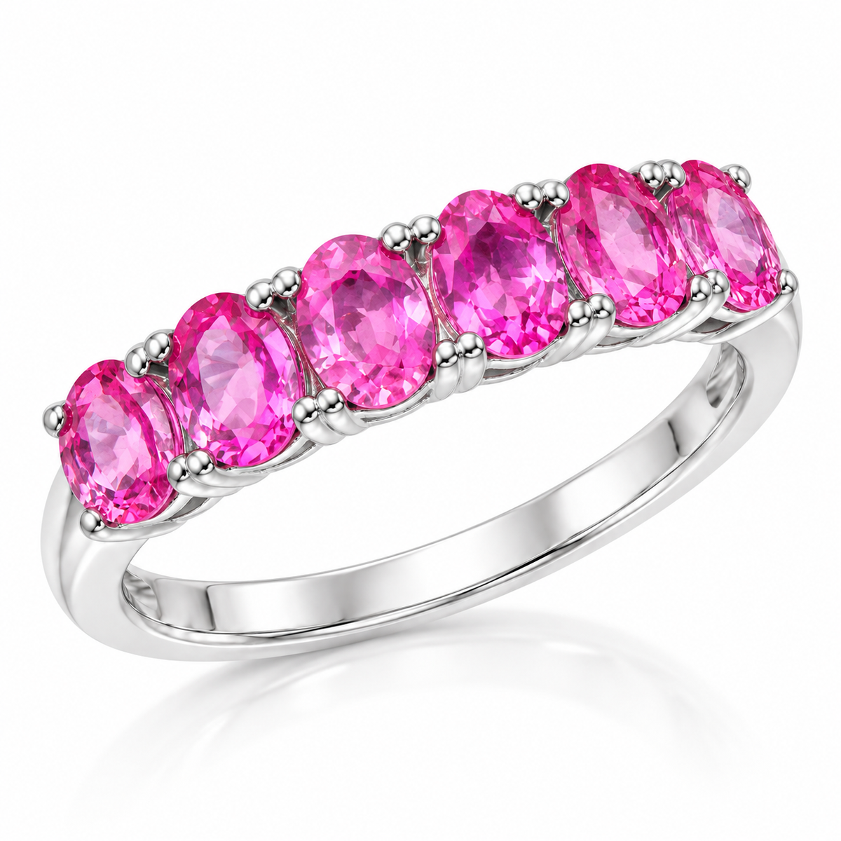 Natural pink sapphire band ring featuring 3x4mm pink gemstones in a 925 sterling silver setting, photographed from a 45-degree angle.