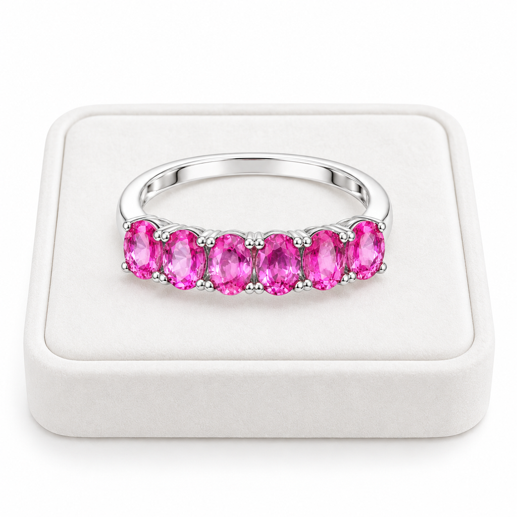 Natural pink sapphire band ring with 3x4mm gemstones displayed on a white velvet jewelry tray.