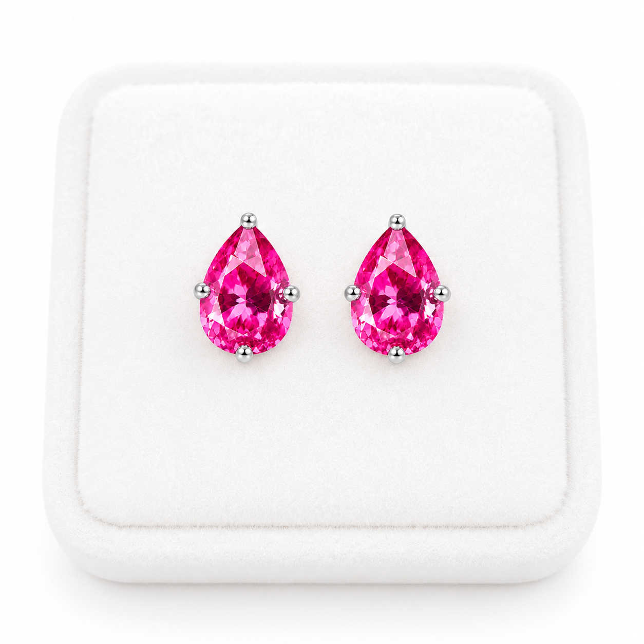 Natural pink topaz pear shaped earrings displayed on white velvet jewelry tray