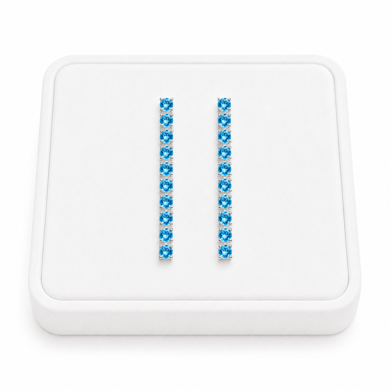 3mm Swiss Blue Topaz dangle earrings displayed on a white velvet jewelry tray