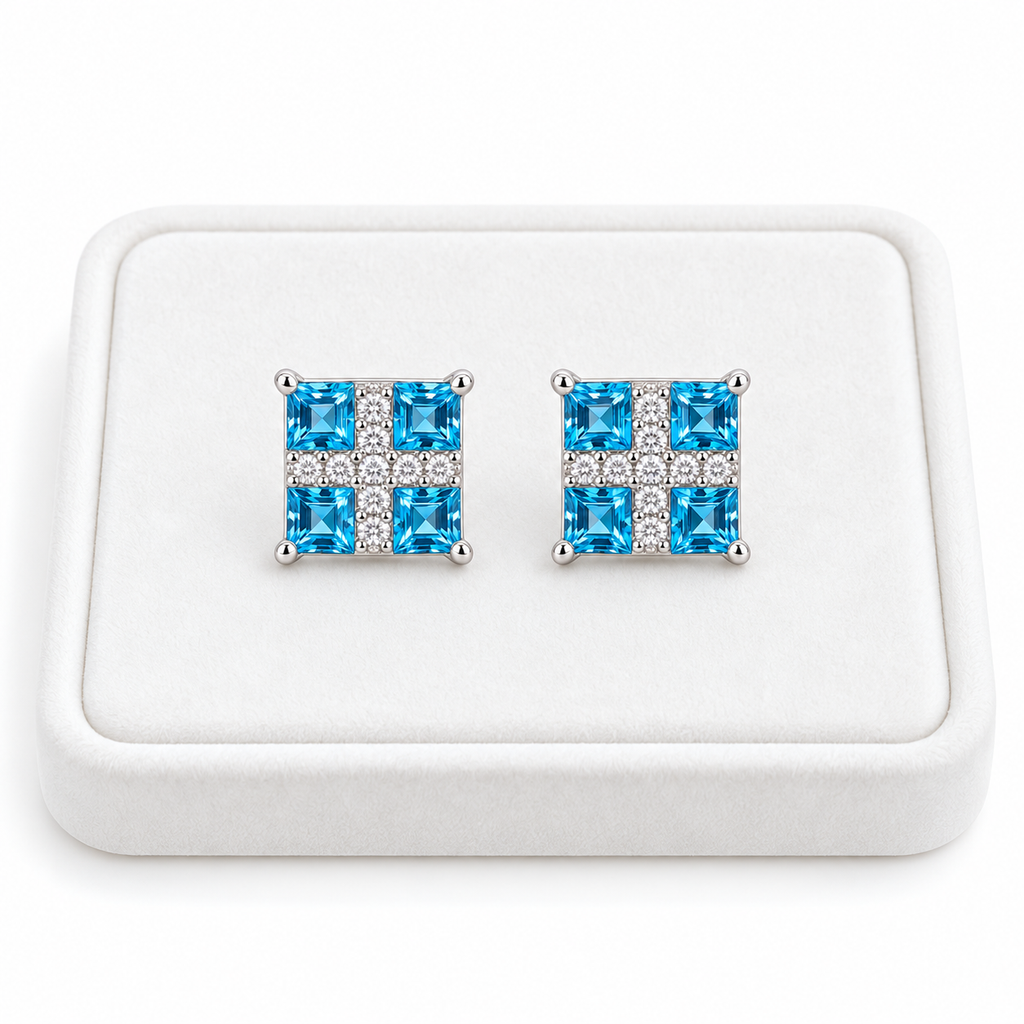 Swiss Blue Topaz stud earrings with 3mm square gemstones displayed on a white velvet tray