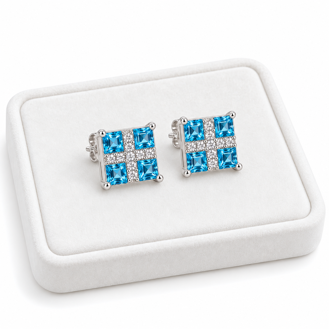 Swiss Blue Topaz stud earrings with 3mm square gemstones displayed on a white velvet tray