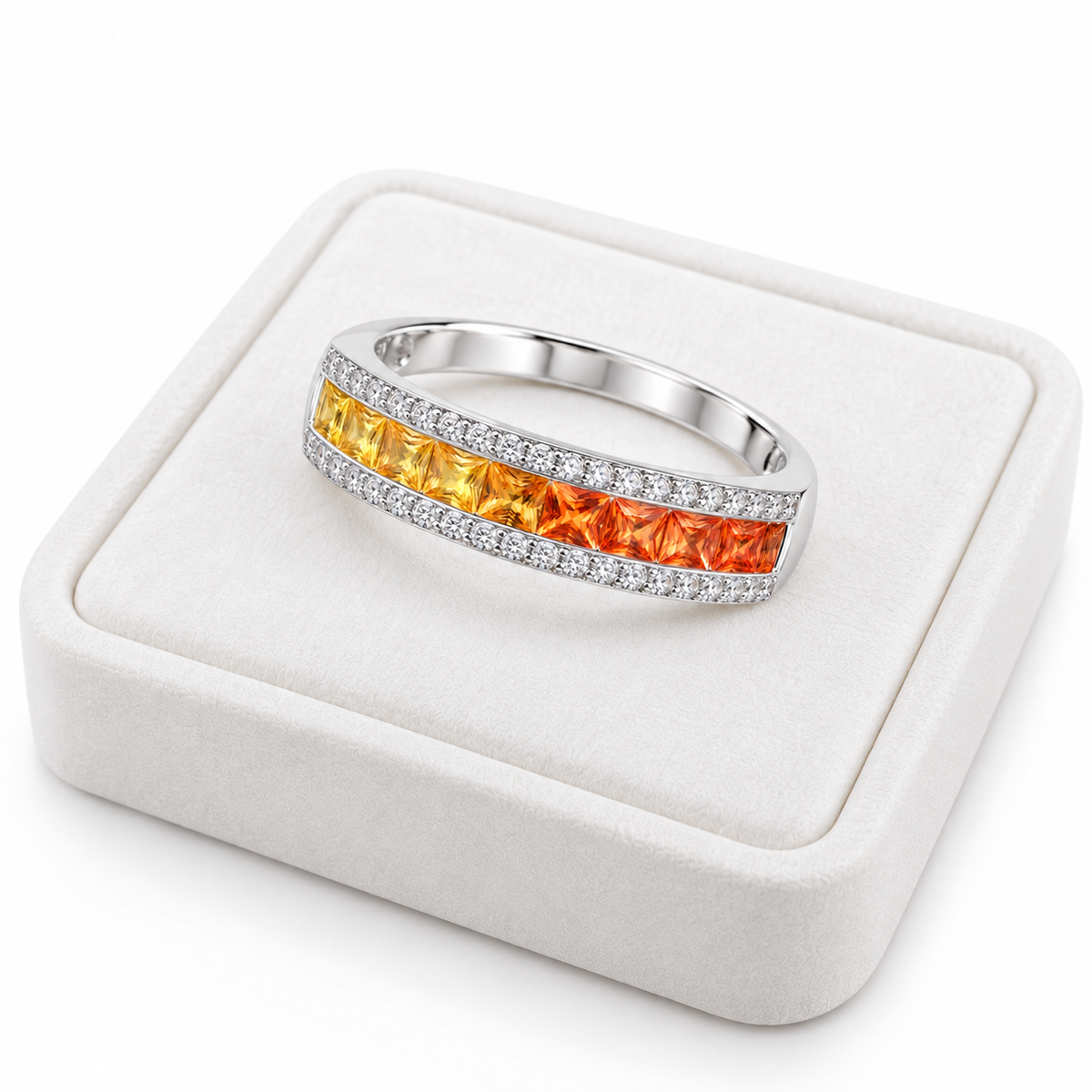 Natural yellow to orange sapphire ring with square 2.2mm gemstones displayed on a white velvet jewelry tray.