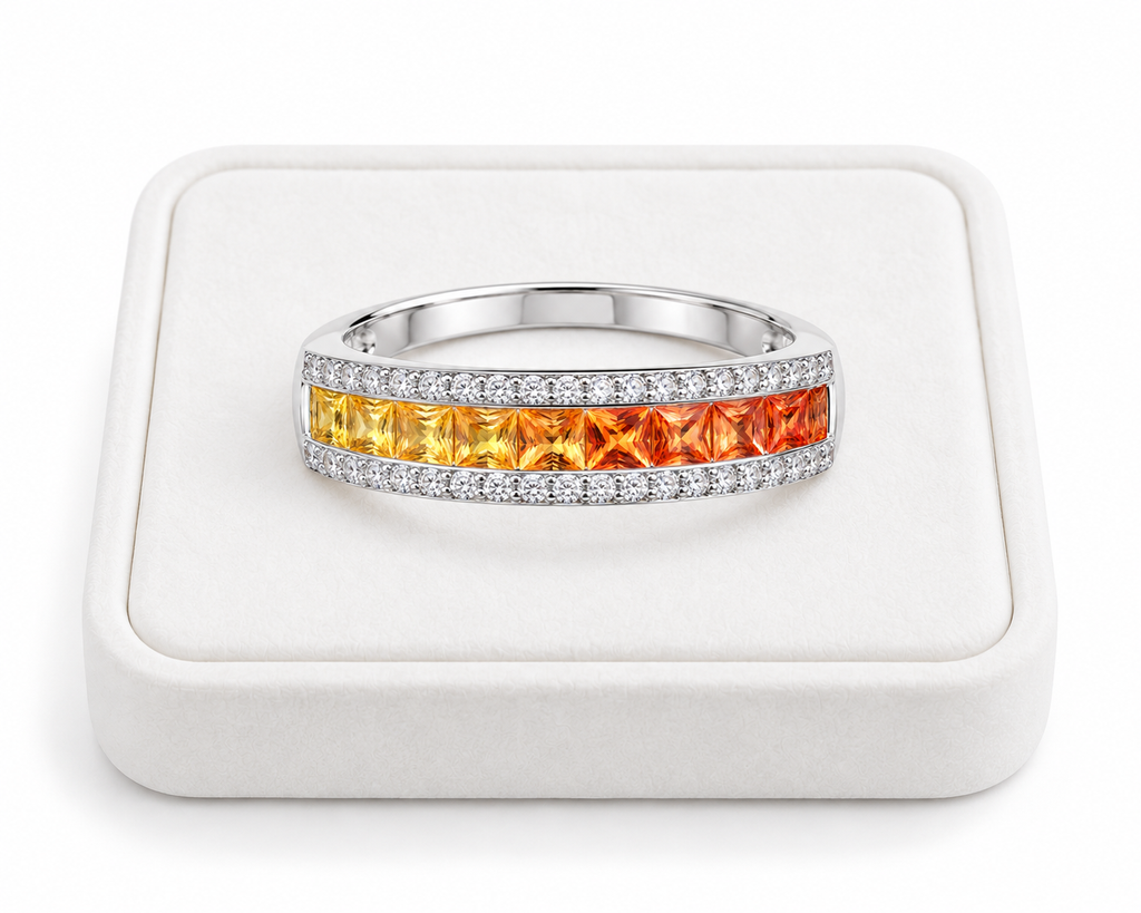 Natural yellow to orange sapphire ring with square 2.2mm gemstones displayed on a white velvet jewelry tray.