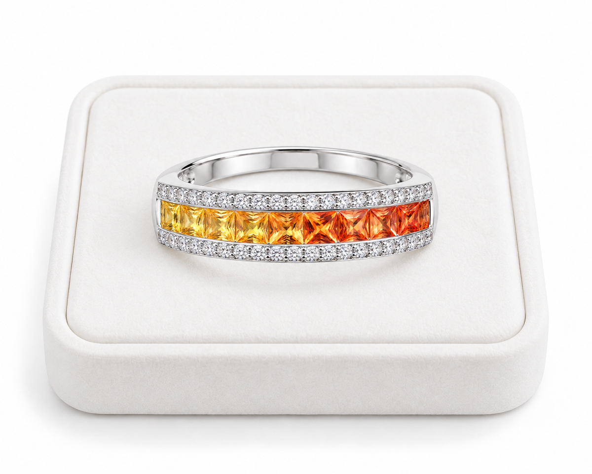 Natural yellow to orange sapphire ring with square 2.2mm gemstones displayed on a white velvet jewelry tray.