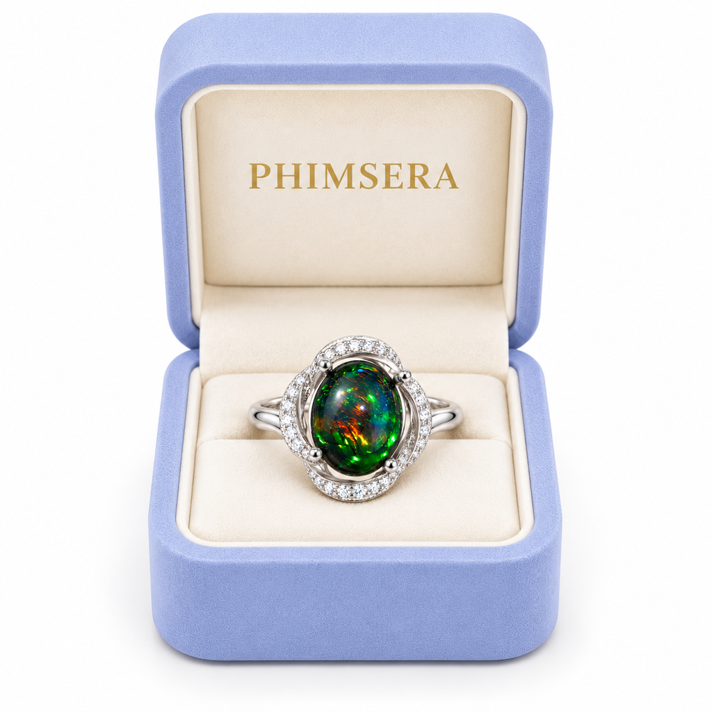 Australian dyed-black fire opal halo ring displayed in a Phimsera jewelry box with an ivory velvet interior.