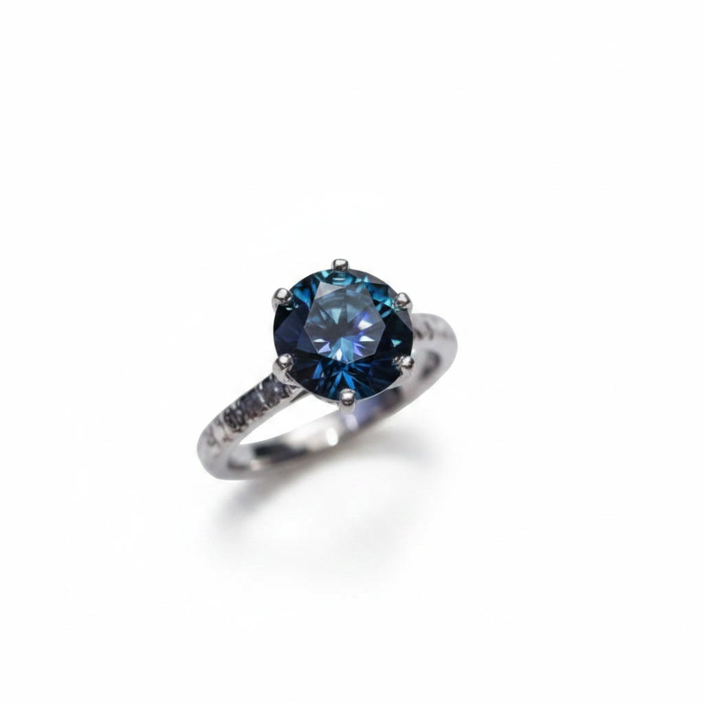 2 carat dark blue round moissanite solitaire ring in platinum plated 925 sterling silver on a white background