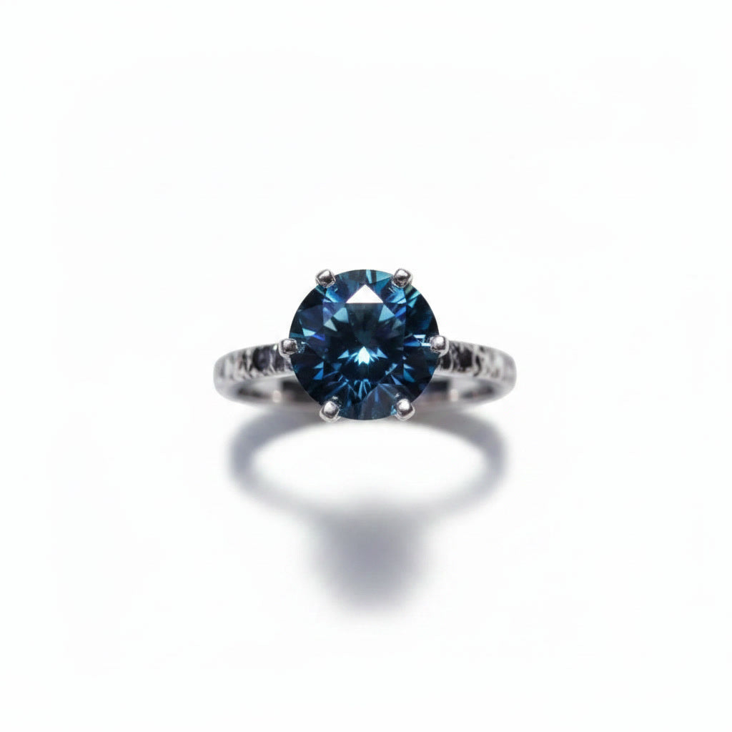 2 carat dark blue round moissanite solitaire ring in platinum plated 925 sterling silver on a white background