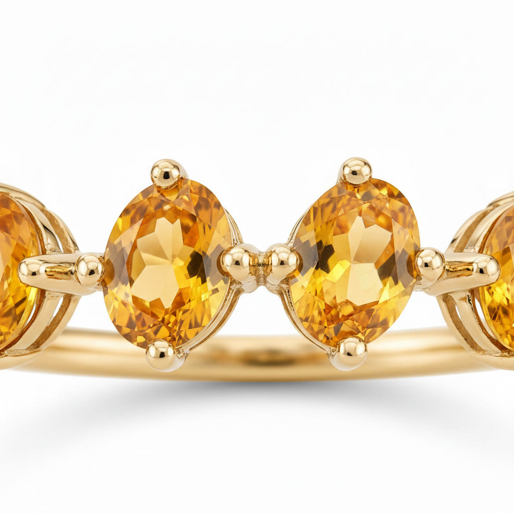 Close-up of four natural golden citrine gemstones in oval-cut ring