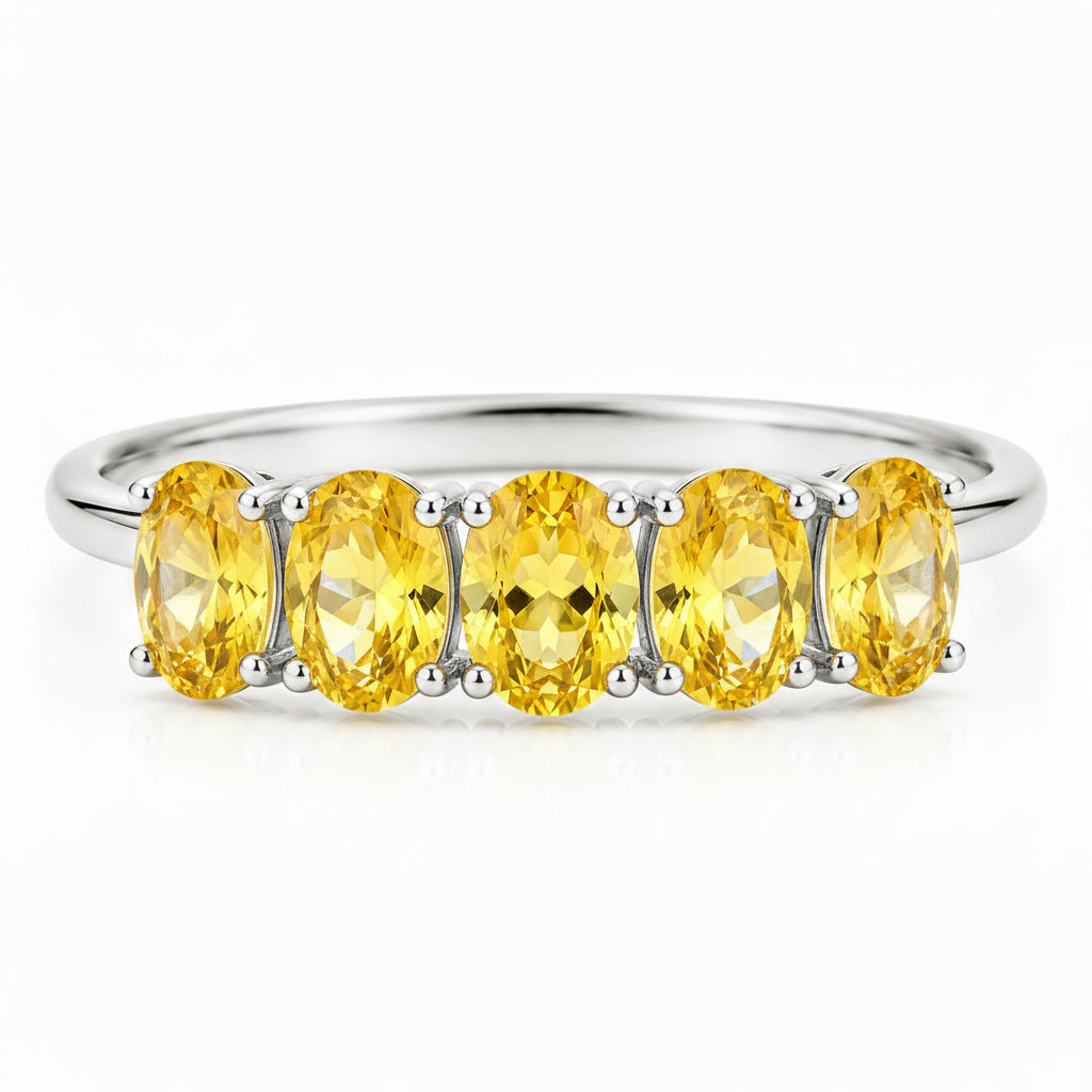 Close-up of five 3x4mm oval natural citrine gemstones in prong settings