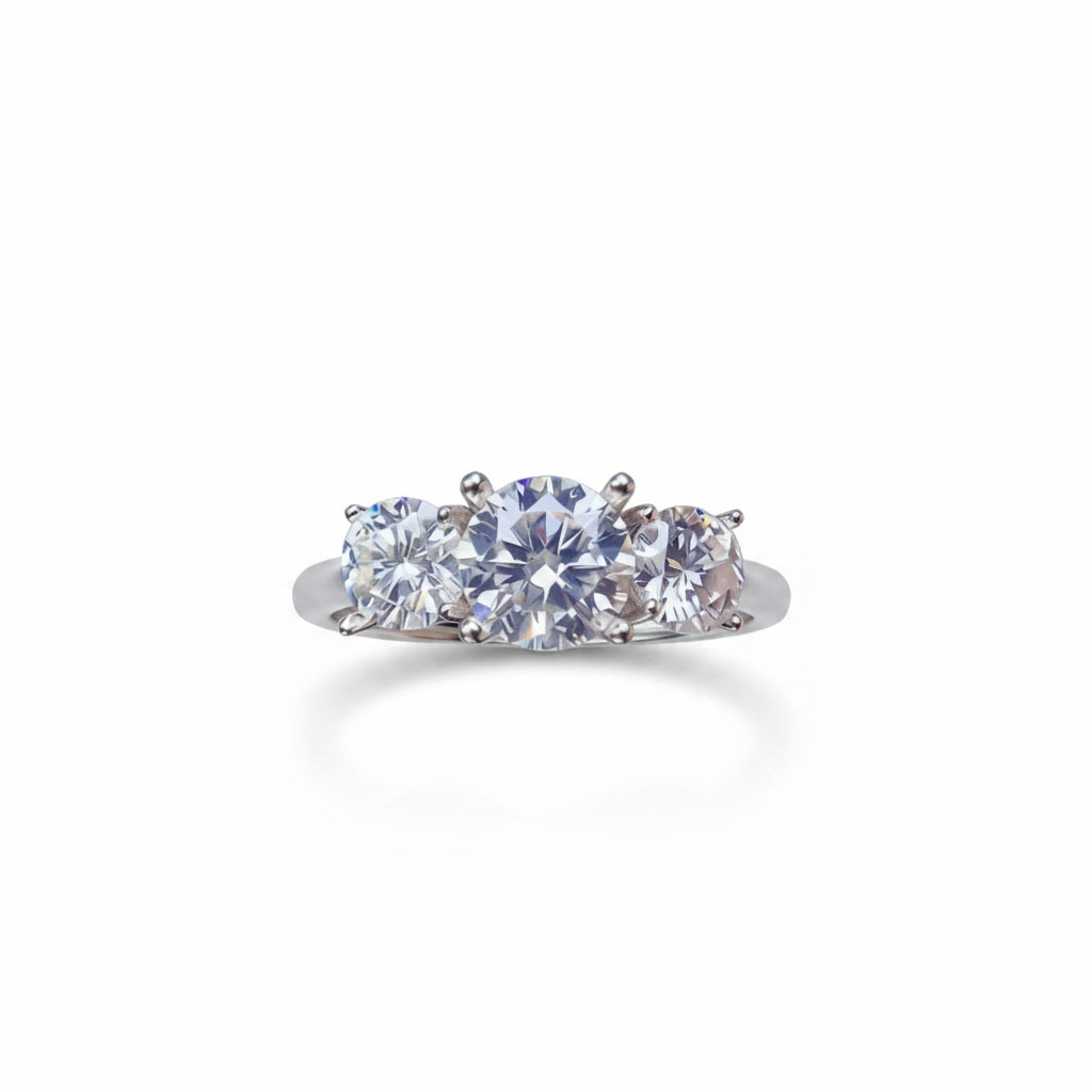 Three stone white moissanite ring featuring a 1 carat round center stone with two 0.5 carat side stones in solid sterling silver with platinum plating.