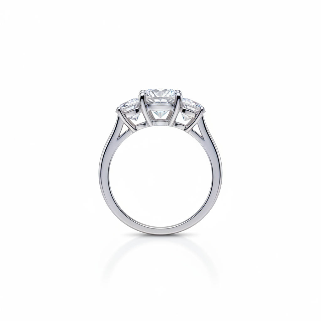 Three stone white moissanite ring featuring a 1 carat round center stone with two 0.5 carat side stones in solid sterling silver with platinum plating.